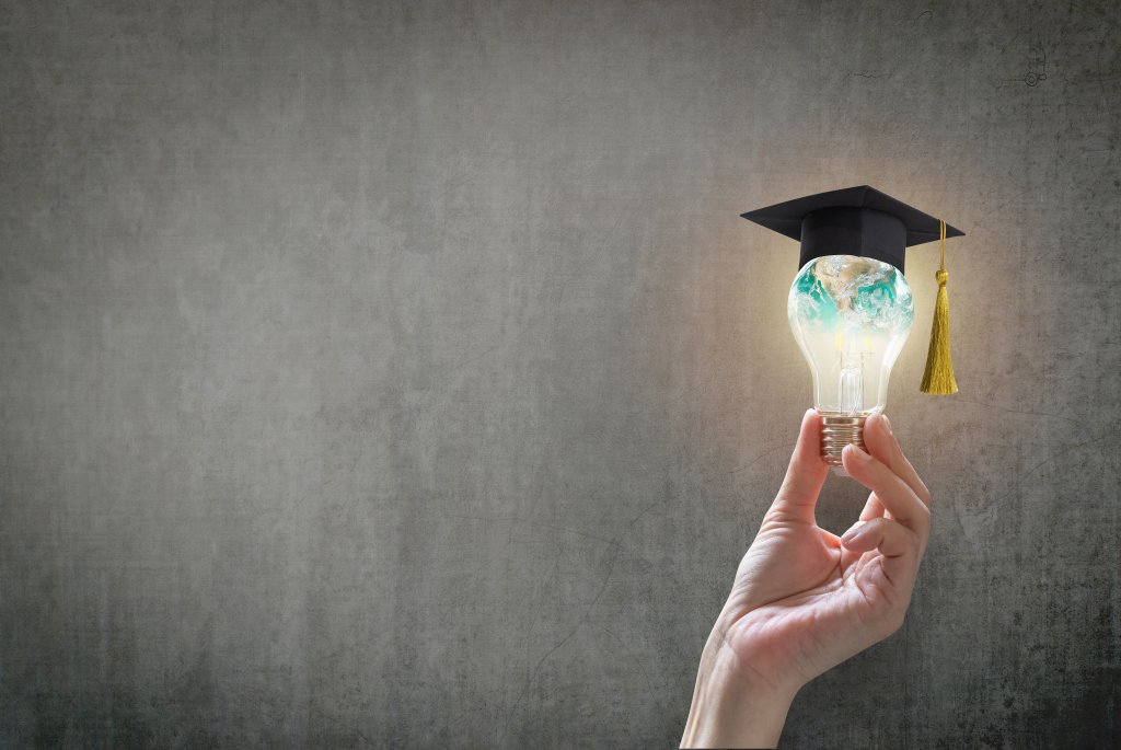Innovative learning, creative educational study concept for graduation and school student success with world lightbulb on teacher chalkboard